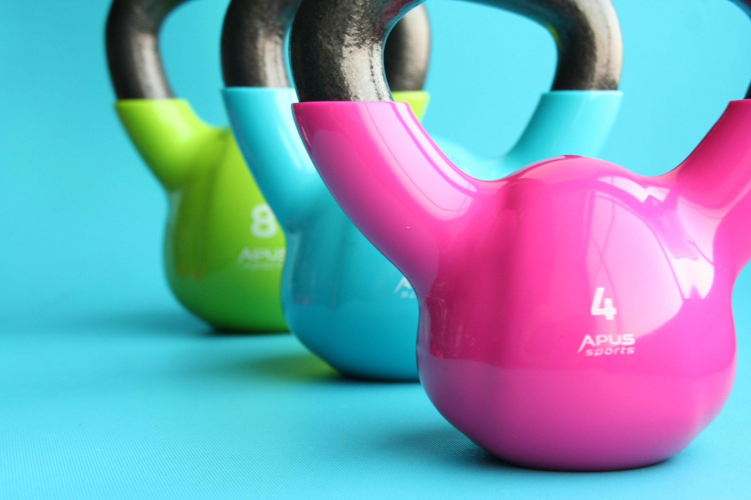 kettlebells in pink, light blue, and lime green