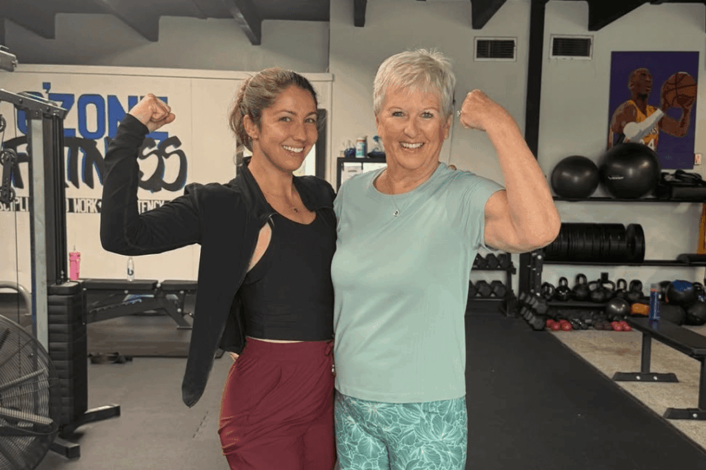 two women showing strength in a gym