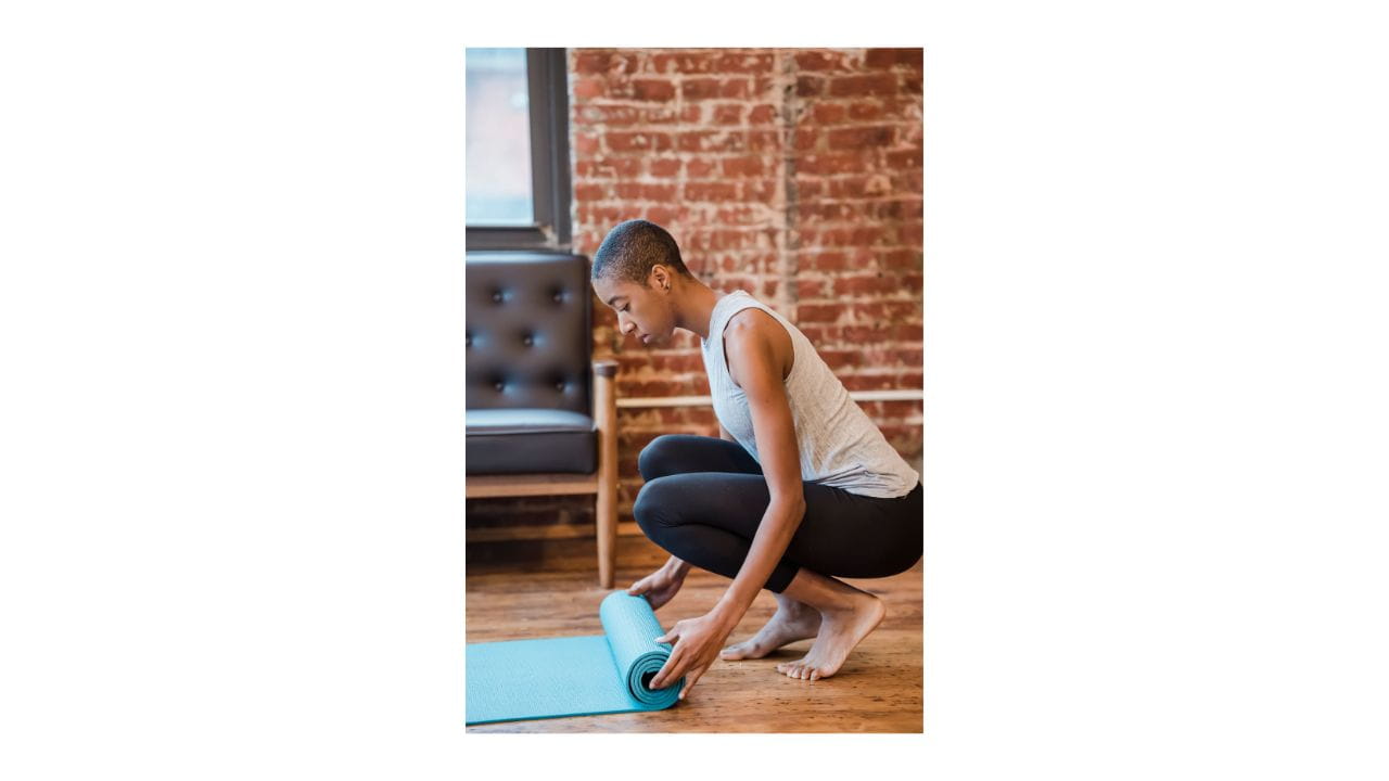 person rolling out yoga mat
